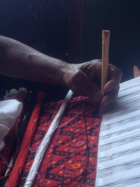 Un hueso de pollo sirve al mismo tiempo para sostener el peinado que para dar volumen al brocado durante el tejido.